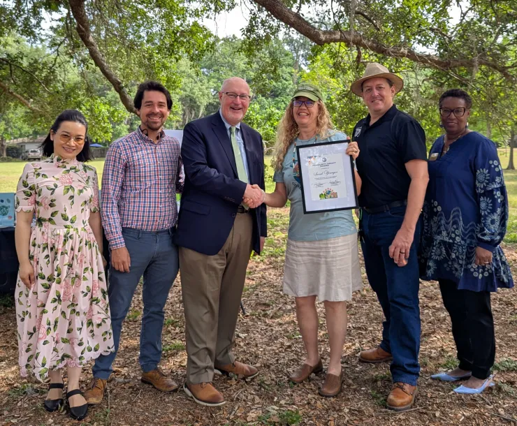 Sarah Younger receiving the Environmental Community Impact award from Gainesville city leaders on Earth Day 2025