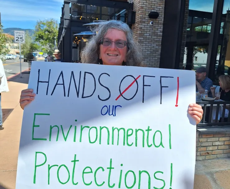Woman holding a sign at the Hands Off protest in 2025