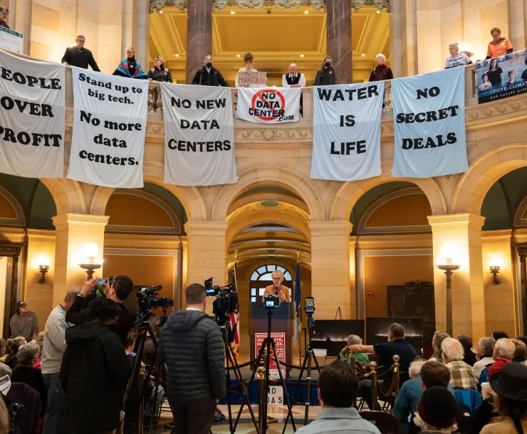 Activists hold banners encouraging accountability for data centers in the Minnesota state capitol rotunda. Photo credit: Devon Young Cupery