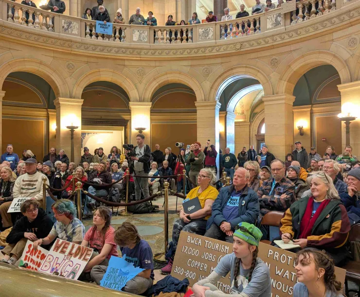 A crowd with signs waiting for a vote.
