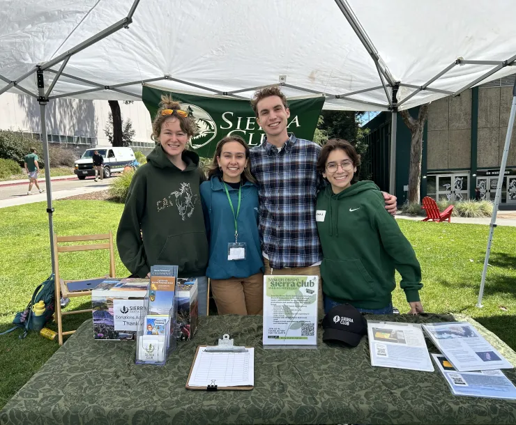 Four students standing at a table with Sierra Club literature