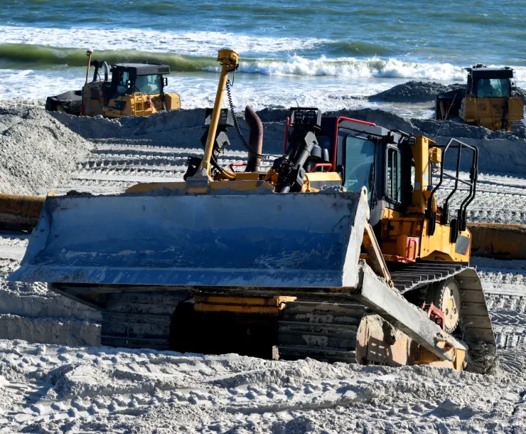 Bulldozer on a beach with ocean in the background