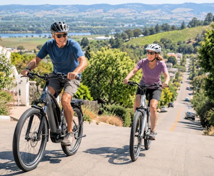 man woman riding ebikes uphill
