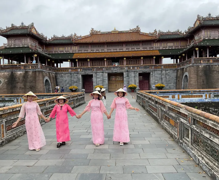 Women in long dresses in front of building