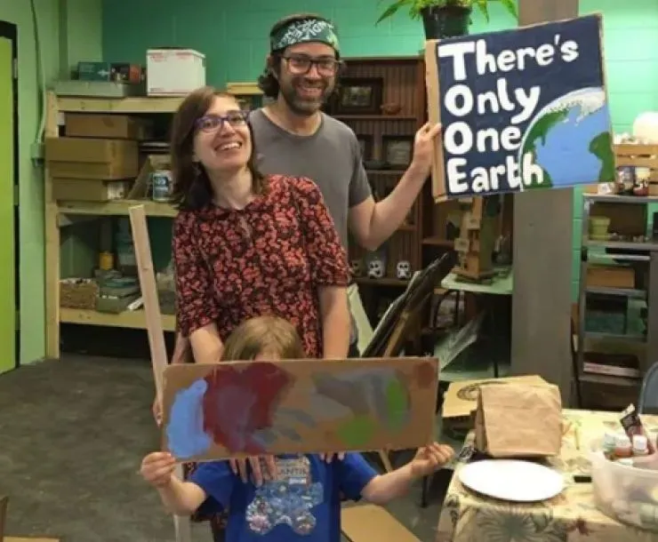 Family advocating for protections from data centers, holding up a sign saying 'There's Only One Earth'.