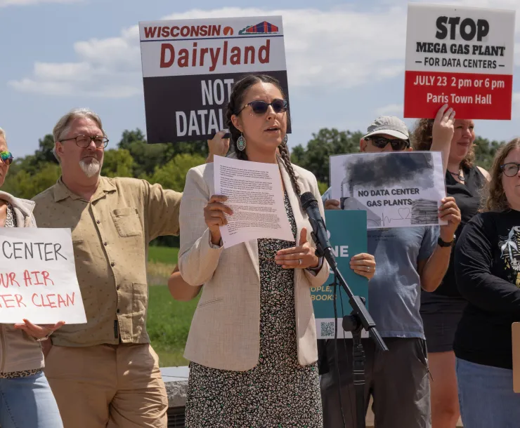 Image of a group of people holding signs that say things like "Stop the mega gas plant"