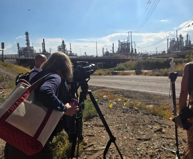 Passengers on the tour look through a camera to see a methane plume not visible to the naked eye at Suncor Refinery.