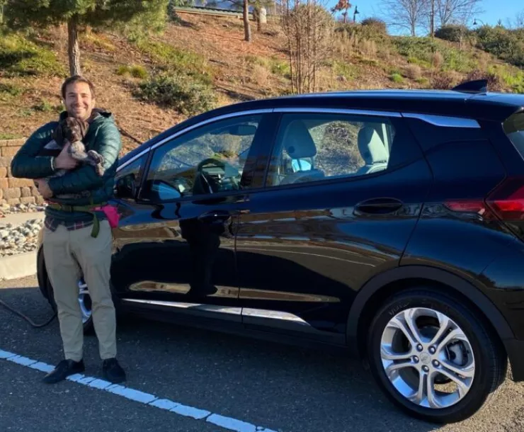 Gregory Young with Chevy Bolt and his puppy Quest Courtesy of Clean Coalition.jpeg