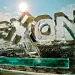 An ice sculpture in the shape of Exxon's logo slowly melting against a bright blue sky. 