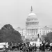 People walk along beside two wagons of the mule train of the Poor People’s Campaign as it makes its way down First St. N/W., past the U.S. Capitol Building