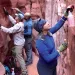 A woman and two men use spray bottles and brushes to clean the walls of the redrock, narrow Spooky Gulch in Grand Staircase–Escalante National Monument.