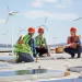 Three workers installing solar panels
