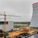 Construction of a nuclear power plant. Tower cranes on the background of the cooling tower.