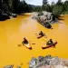 People kayak in water colored from a mine waste spill at the Animas River near Durango, CO
