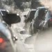 Blurred silhouettes of cars surrounded by steam from the exhaust pipes