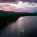 Sunrise or sunset aerial photo of a reservoir with a boat and its wake