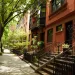 A row of brownstone homes with trees planted out front