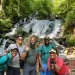 5 people pose in front of a waterfall