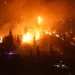 The McDougall Creek wildfire burns on the mountainside above a lakefront home in West Kelowna, Canada on Friday, Aug. 18, 2023