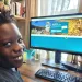 A boy smiles in front of a computer displaying everykidoutdoors.gov
