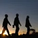 Silhouette of workers at oil refinery