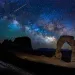The Milky Way over a red rock arch. 