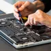 Man repairing laptop with screwdriver