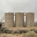 Industrial oil and gas infrastructure next to a sign that says "Entering Your Public Lands"