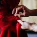 Close-up of woman's hands sewing with needle. 