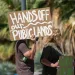 A person holding a sign that says, "Hands off our public lands"