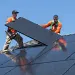 2 solar installers installing a solar panel on a roof; Taken by photographer Henrik Kam
