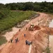 A muddy road under construction in a rainforest 