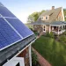 Len Bicknell walks from his house to his garage where his solar energy panels are mounted on the roof in Marshfield, Mass. Renewable energy interests are flexing their newfound power not just with solar panels and wind turbines but in the corridors of the Massachusetts Statehouse.