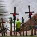 A man walks past crosses and flowers that form a make-shift memorial along the Guadalupe River as the Texas Senate and House Select Committees on Disaster Preparedness and Flooding hold a public hearing in Kerrville, Texas