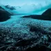 A dark sky and mist appear above the mountain and ice of Svínafellsjökull glacier in Iceland.