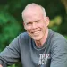Portrait of Bill McKibben sitting and smiling at the camera