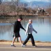 Two people stroll through a snowless Denver park this past winter.
