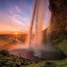 A sight to keep you up at night, delightfully: The setting midnight sun and Iceland’s Seljalandsfoss waterfall.