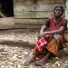 Yaa Konadu sits outside the farmhouse in Ghana that Newmont took away from her. Company workers spray-painted "Done" on the wall.