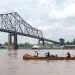 Paddling a handmade canoe under a bridge in Helena, Arkansas, en route from St. Louis to the mouth of the Mississippi.