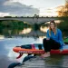 Lizzie Carr sits on a paddleboard on a dock next to the River Trent, Nottingham, UK.