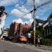 A young man prepares to take a shot at a basketball hoop set up on the street in front of houses in Pittsburgh. Four other young men stand around.