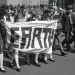 Students in their school uniforms walk and hold a banner that says Earth, on the first Earth Day in 1970.