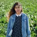 Magaly Santos stands in front of what appears to be a field of lettuce.