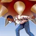 Illustration shows a black man with a mask carrying a large spiky coronavirus on his back.