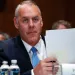 Secretary of the Interior Ryan Zinke holding papers during a hearing.