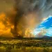 Enormous cloud with firey orange and yellow interior against a blue sky