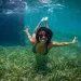 Marine biologist Ayana Elizabeth Johnson swimming underwater over a field of seagrass.