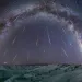 Clusters of stars in a rainbow curve in the night sky.