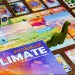 Box for tabletop game "Evolution" with colorful cards and game pieces arrayed around it.